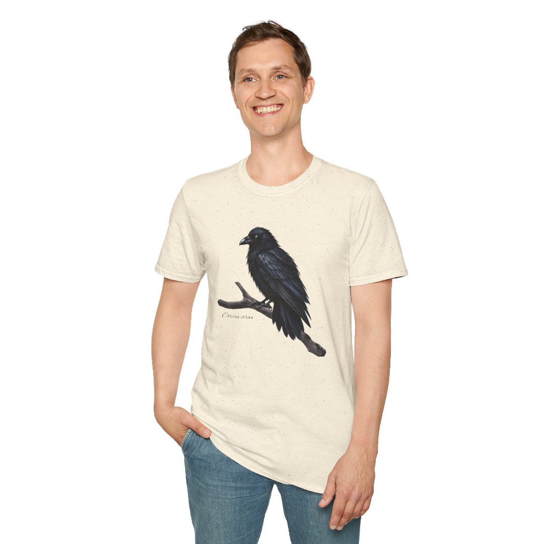 Hippuli brändin beige unisex puuvillainen t-paita, jossa on maalattu kuva puunoksalla istuvasta Corvus corax -korpista. Kuvassa miehen päällä.