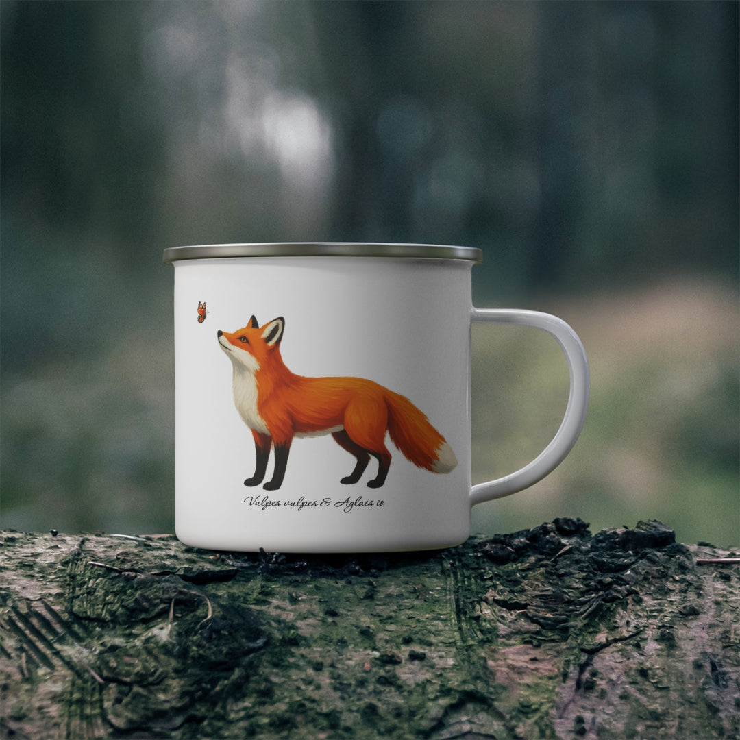 Hippuli brändin valkoinen emalimuki, jossa on maalattu kuva lentävää Aglais io -neitoperhosta katselevasta Vulpes vulpes -ketusta. Kuva luonnossa.